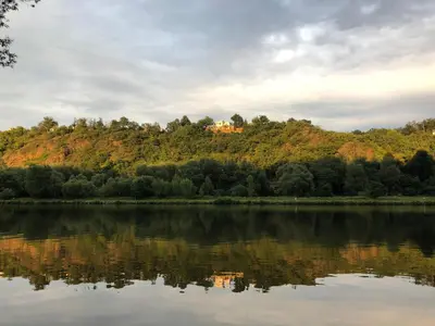 a house on top of a hill next to a lake at Apartmán - E - Vyhlídka nad řekou in Zdiby