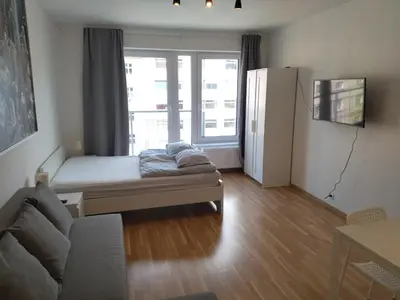 a living room with a couch and a large window at Brand new studio apartment # 42 in brand new building with free parking in the center in Prague