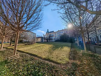 a park with trees and buildings in a city at Flat in Zizkov -103- in Prague