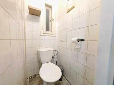 a white bathroom with a toilet and a window at Apartment in Zizkov -201- in Prague