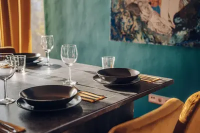 a table with plates and wine glasses on it at Design 3BD apartment cooking area in architect villa in Prague