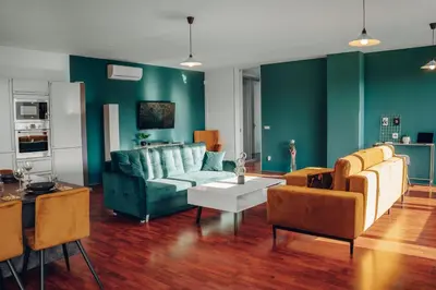 a living room with green walls and a blue couch at Design Architect Villa with 2 Apartments in Prague