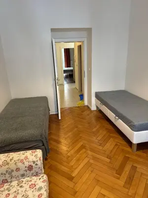 two beds in a room with a wooden floor at 2 Bed Flat - Sleeps 9 - Pets - Smoking on terrace in Prague