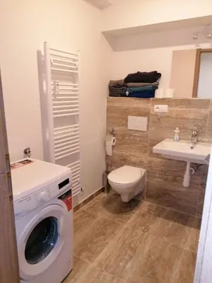 a bathroom with a washing machine and a sink at Brand new studio apartment # 45 with free parking in the city center in Prague
