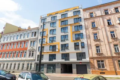a tall building with cars parked in front of it at Brand new studio apartment # 45 with free parking in the city center in Prague