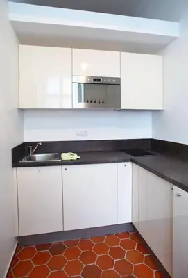 a kitchen with white cabinets and a sink at Grey cozy apartment in Prague