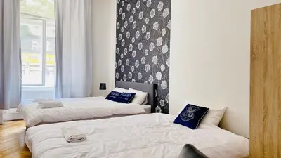 a bedroom with two beds and a wall with a window at aparthotel in Prague Centre in Prague