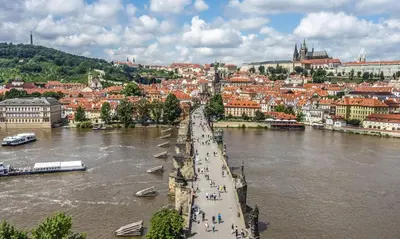 a bridge over a river with a city in the background at Spacious apartments near the river Prague in Prague