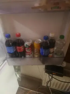 a shelf with a bunch of soda bottles on it at Villa Barrandovská in Prague
