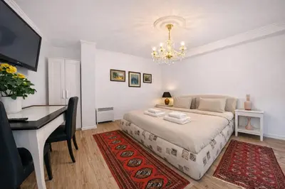 a bedroom with a bed and a desk and a computer at Garden Suite - KindStay Suites Prague Airport in Kněžívka