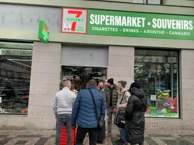 a group of people standing outside of a store at TDC31, boo in Prague