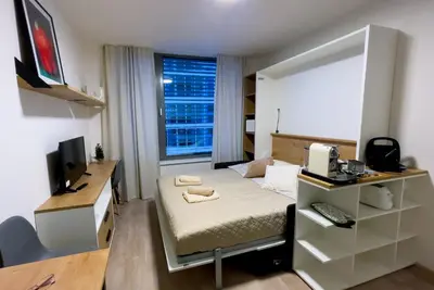a small room with a bed and a desk with a computer at Rezidence My Mozart in Prague