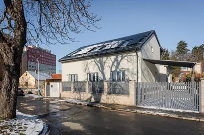 a white building with a solar roof on a street at Apartmán Praha in Prague