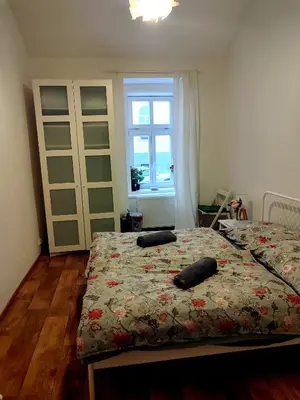 a bedroom with two beds and a window at Nice room with double bed in zizkov - shared bathroom in Prague