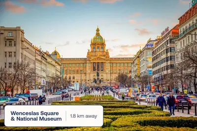 a large building with a clock tower in a city at TurnKey I Karlín Square Apartments in Prague