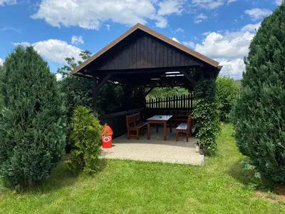 a gazebo with a table and chairs in a garden at Penzion Kamejk in Kamýk nad Vltavou