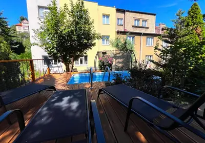 a deck with two benches and a swimming pool at Apartmán l Praha centrum in Prague