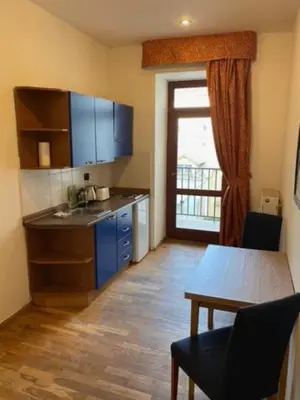 a kitchen with a sink and a table and a door at Vitkova apartment with balcony in Prague