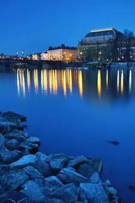 a large body of water at night with buildings at Small Sunny park view apartment in Prague