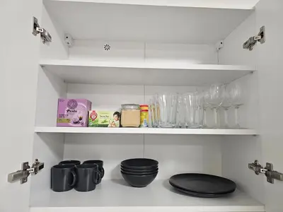 a kitchen shelf with glasses and other items on it at Apartment - O2 Arena Prague with parking in Prague