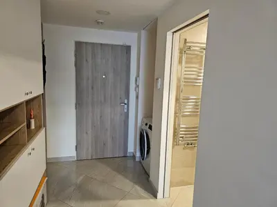 a kitchen with a washer and dryer next to a door at Apartment - O2 Arena Prague with parking in Prague