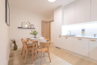 a kitchen and dining room with a table and chairs at Bright 2BR - 7th floor, Balcony, Free Parking by Gravity Prague in Prague