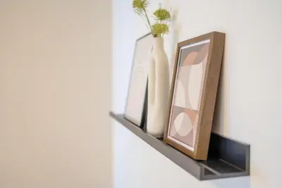 a shelf with two vases and a mirror on it at Bright 2BR - 7th floor, Balcony, Free Parking by Gravity Prague in Prague