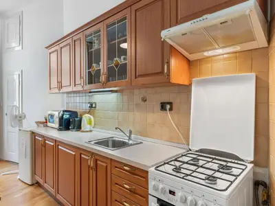 a kitchen with wooden cabinets and a white stove top oven at Apartment Old Town home-2 by Interhome in Prague