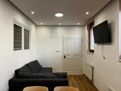 a living room with a couch and a flat screen tv at Two Modern Apartments with Complimentary Parking in Prague