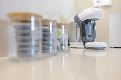 a coffee maker and cups on a counter at Bright 2BR - 5th floor, Balcony, Free Parking by Gravity Prague in Prague