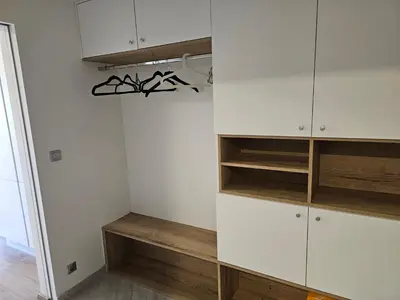 a closet with white cabinets and wooden shelves at NEW Apartment - O2 Arena Prague with parking in Prague