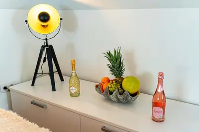 a table with a bowl of fruit and wine bottles at Golden River Apartment in Prague