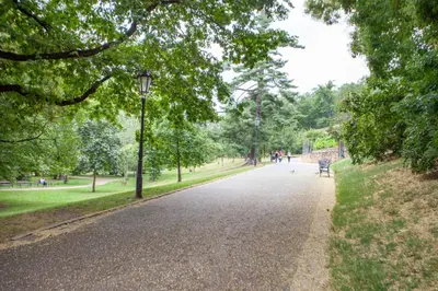 a street in a park with a bench and trees at Blueground Vršovice furnished equipped PRG-5 in Prague