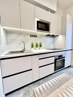 a white kitchen with a sink and a microwave at Apartment in the center on Sokolska street in Prague