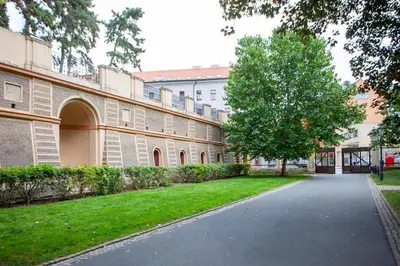 a building with a tree in the middle of a driveway at Blueground - Vrsovice, furnished in Prague