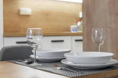 a table with two wine glasses and a plate and bowl at SMART Studio with Ultra Fast 1Gbps WiFi and Air Conditioning in Prague