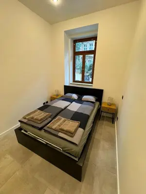 a large bed in a room with a window at Cool Vitkova apartment with balcony in Prague