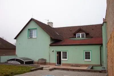 a kitchen with a table and a white refrigerator at Apartmán se společným bazénem Zlonice in Zlonice