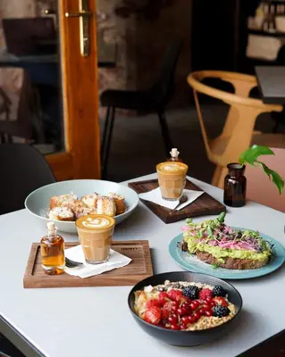 a table with plates of food and cups of coffee at Apartment Dusni in Prague
