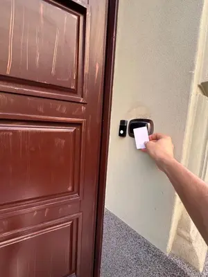 a person unlocking a door with a piece of paper at 8- Little Prague Home in Prague