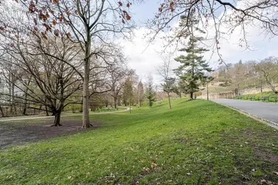 a park with green grass and trees and a road at Blueground Rostovska str renovated furnished PRG-19 in Prague