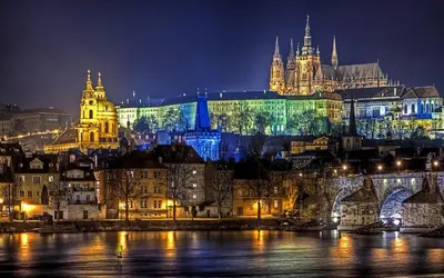 a city lit up at night with a castle at Victory Deluxe Suite in Prague