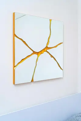 a mirror with a wooden frame hanging on a white wall at Victory Deluxe Suite in Prague