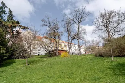 a grassy field with a building in the background at Blueground Vršovice private terrace equipped PRG-8 in Prague