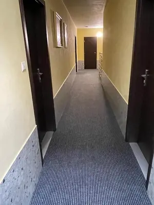 an empty hallway with two open doors and a hallwayngth at Hotel Jahodnice in Prague