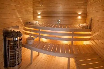 a wooden sauna with two benches and a trash can at House Big Win Mělník in Mlazice