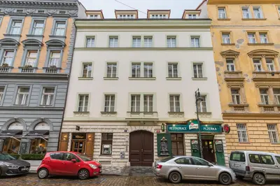 a white building with cars parked in front of it at Antiveli Residence in Prague