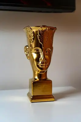 a gold vase with a face on it on a table at Kingdom River Deluxe in Prague