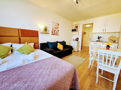 a bedroom with a bed and a living room at LIVE-INN PRAGUE SUPERIOR SUITE FOR 1-4 GUESTS, 20 Mins to center, Lift, Gym, Reception, Parking, Roof Terrace, Game & Party Room in Prague