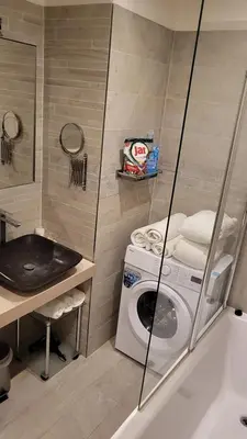 a bathroom with a washing machine and a sink at Premium Apt - Free Massages from Physiotherapists in Prague